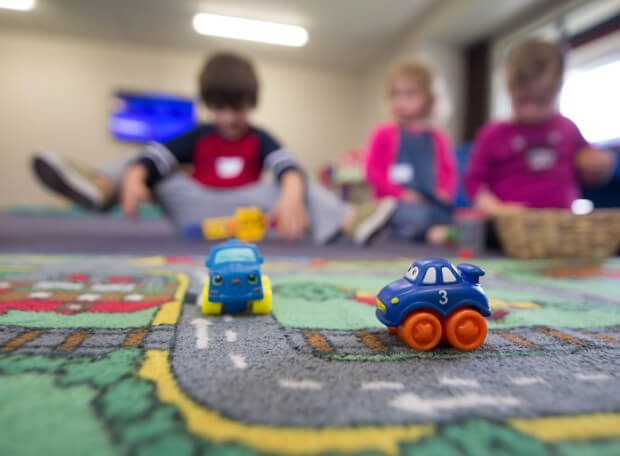 Children playing with toy cars indoors, symbolizing the safety and non-toxicity of lamination materials used in packaging