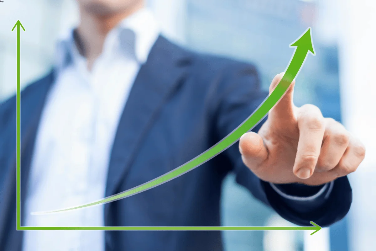 Businessman pointing at a rising green growth chart, symbolizing customer benefits from XLD packaging solutions