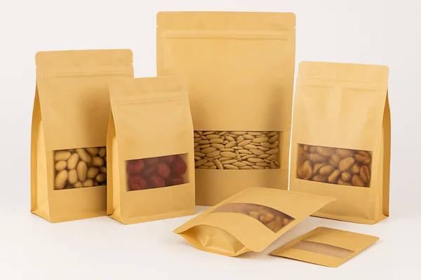Eco-friendly kraft paper stand up pouch samples from XLD Packaging with transparent windows, ideal for nuts, dried fruits, and snacks.