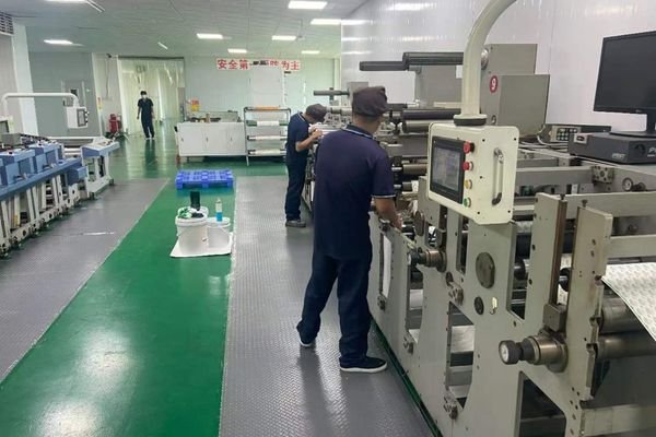 XLD Technicians operating pouch-making and converting machines inside a clean flexible packaging production facility